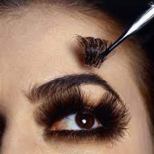 What is the trick to putting on false eyelashes?